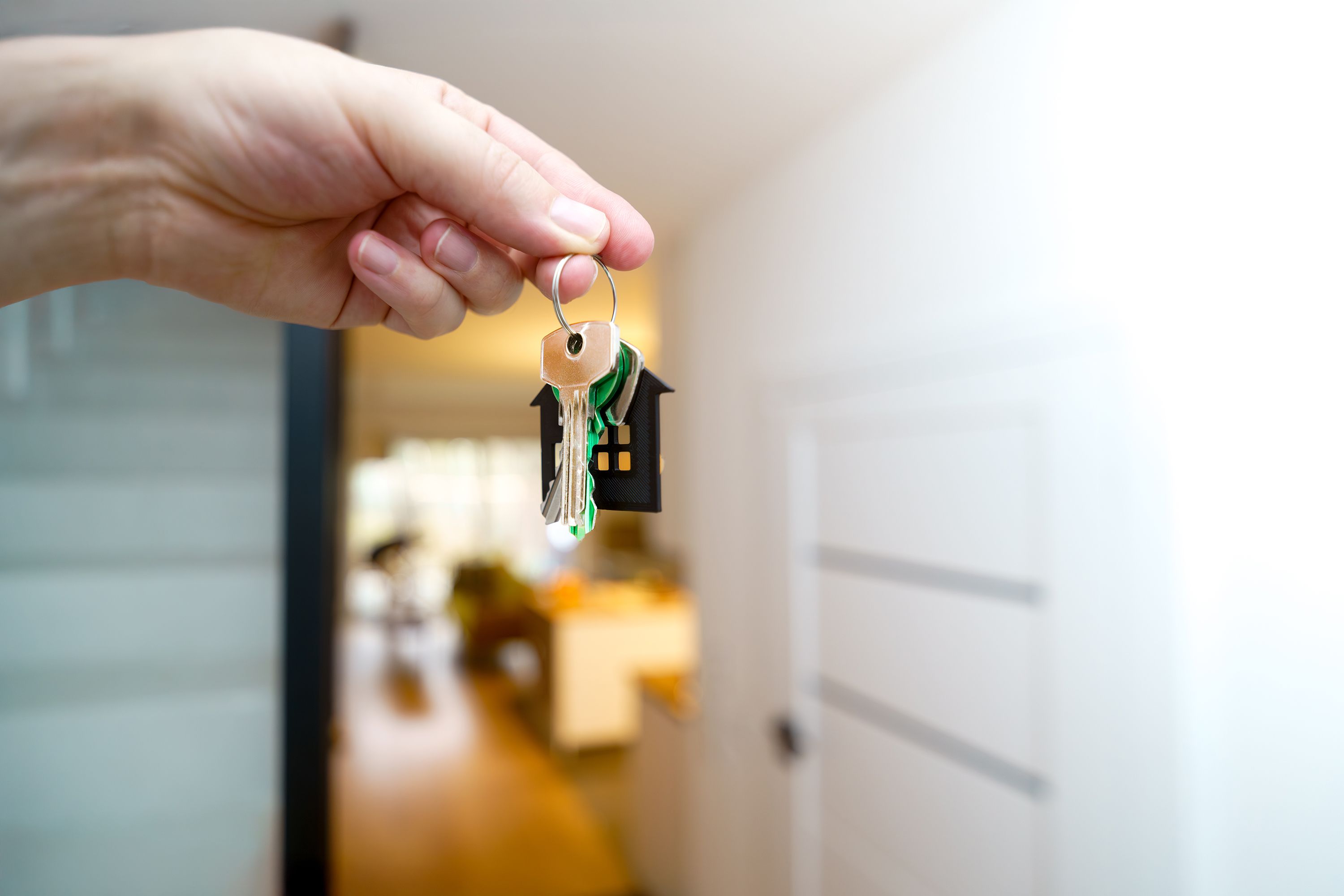 House keys being held inside a home representing tenant placement and rental property investment